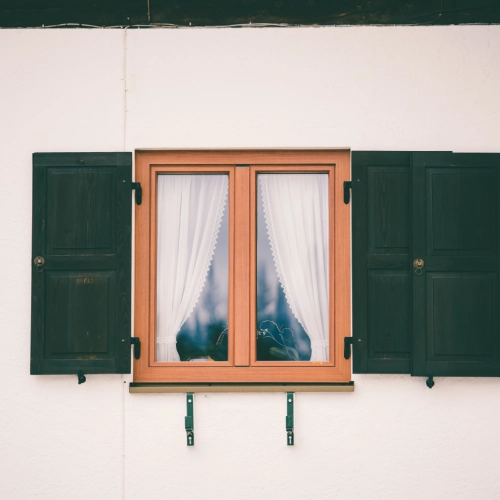 glass window with wooden frame white curtain inside